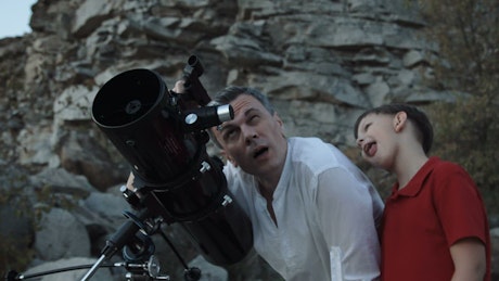Father and son using telescope