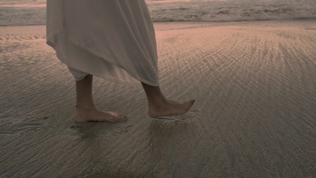 Feet walking on the beach.