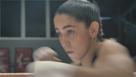 Female boxer training on the ring.