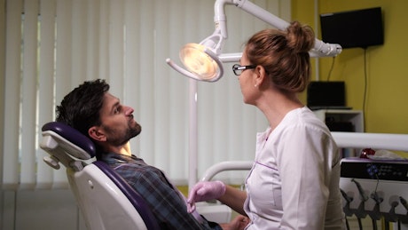 Female Dentist checking her patient