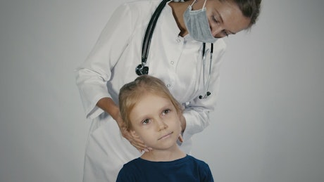 Female doctor checking the lymph node of the child
