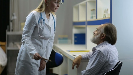 Female doctor doing a medical checkup to a man.