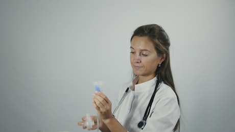 Female doctor testing an inhaler.