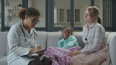 Female doctor visiting a sick girl.