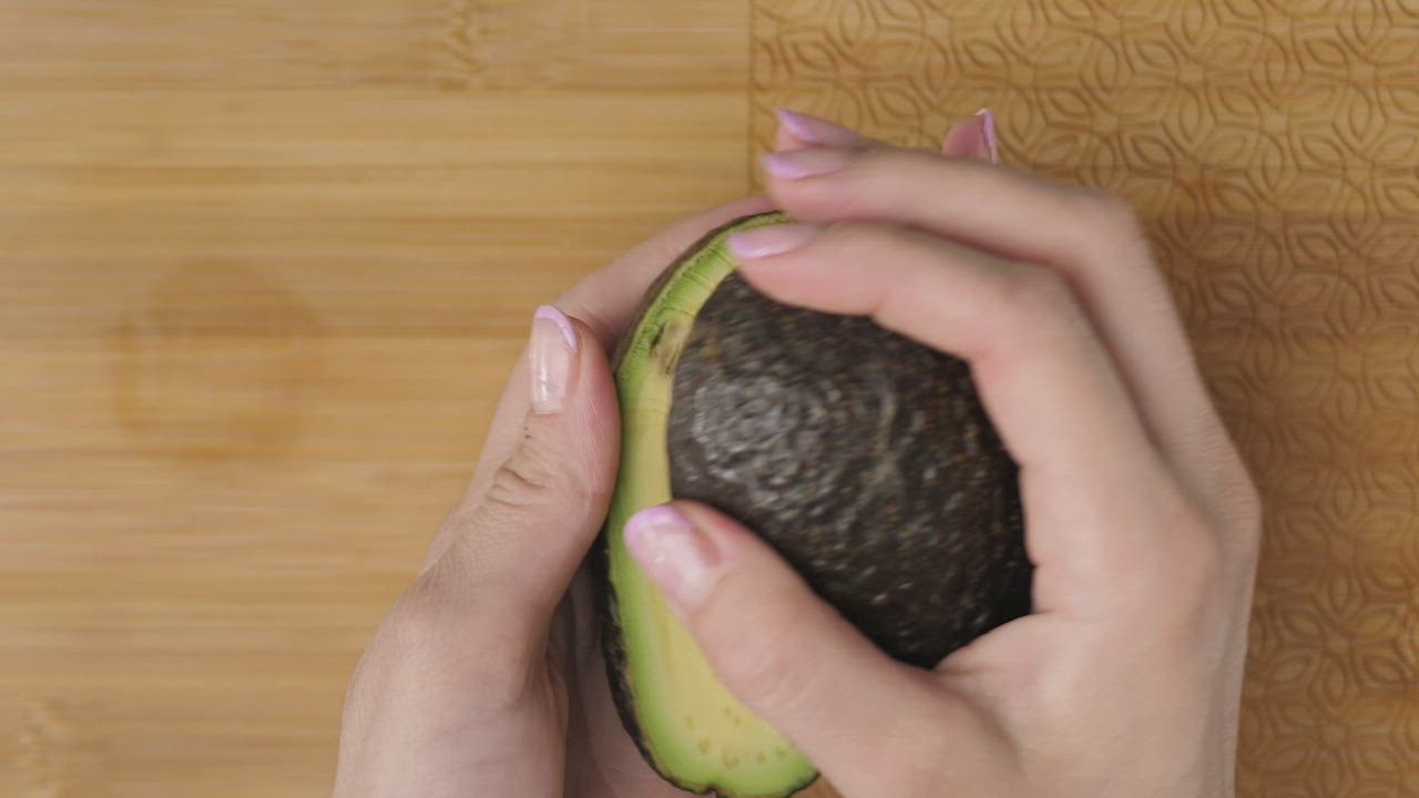 Female hands  live draw super wuhan cutting an avocado in the kitchen