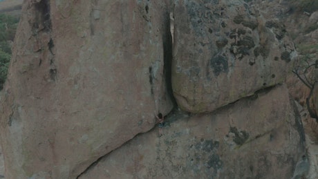 Female mountain climber scaling huge rock formations.