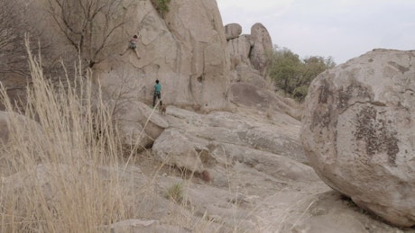 Female mountaineer climbing a huge rock