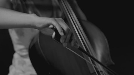 Female musician playing the cello in black and white.