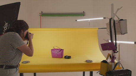 Female photographer taking product photos on a set.