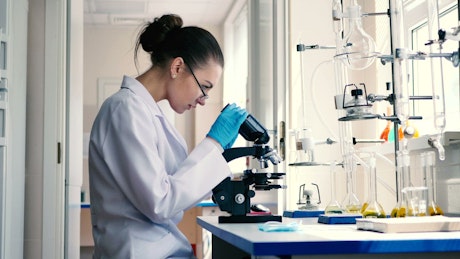 Female scientist observing through a microscope