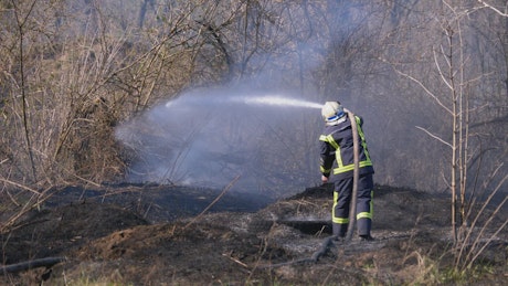 Fire fighter with water hose.