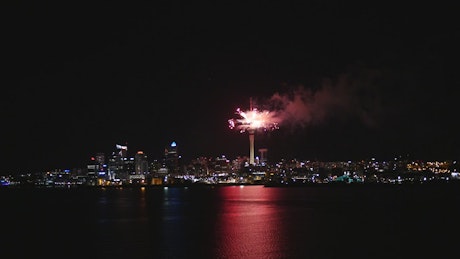 Fireworks in the top of a tower and the city lights