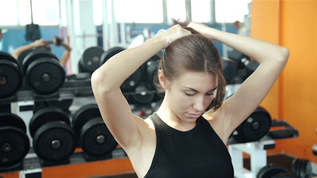 Fitness woman sets her hair before training