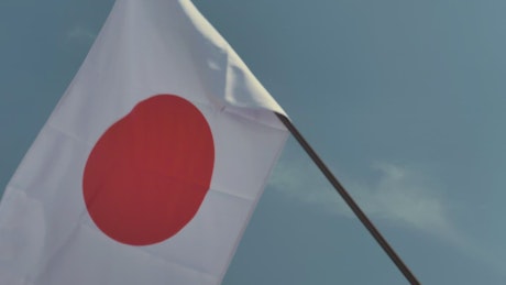 Flag of Japan waving on a flagpole.