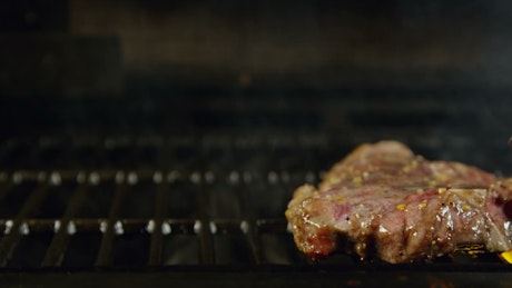 Flipping a flame grilled steak.