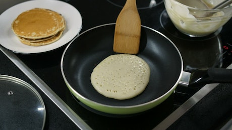 Flipping a pancake on a stove