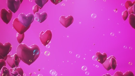 Floating heart shaped balloons on pink background and bubbles.