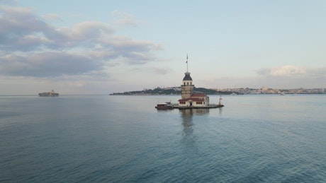 Floating lighthouse on a sea coast with boats.