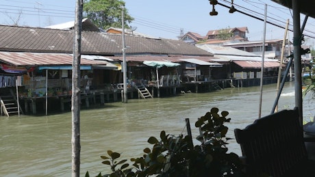 Floating market with a speeding boat passing by