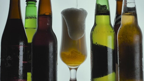Foamy beer spilling from a glass.