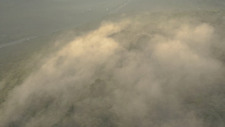 Fog covered hill in an aerial shot.