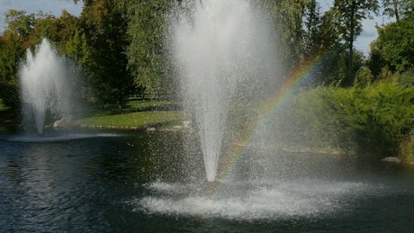 Fountains in the lake with a rainbow.