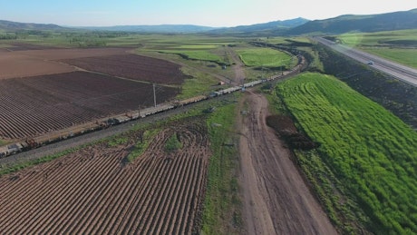 Freight train moving through agricultural fields