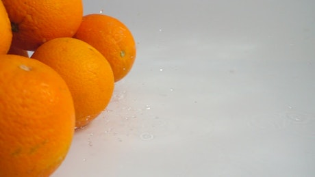 Fresh oranges rolling through water