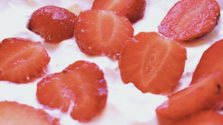 Fresh strawberries lying in organic yoghurt.