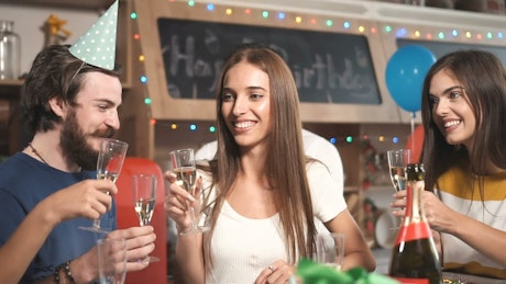 Friends celebrate with champagne at birthday party