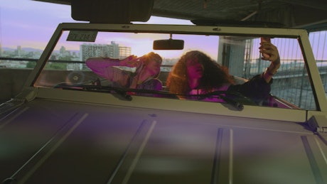Friends taking a selfie in a car.