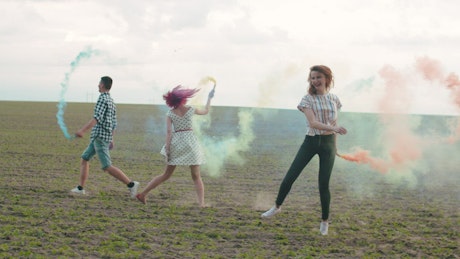 Friends with colored smoke bombs.