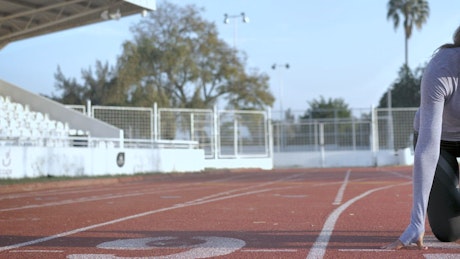 Front view of a female runner in the start position.