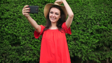 Funny girl taking selfies wearing a red dress