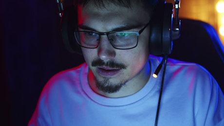 Gamer illuminated by a screen having fun online.