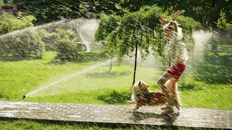 Girl and dog running in the park path.