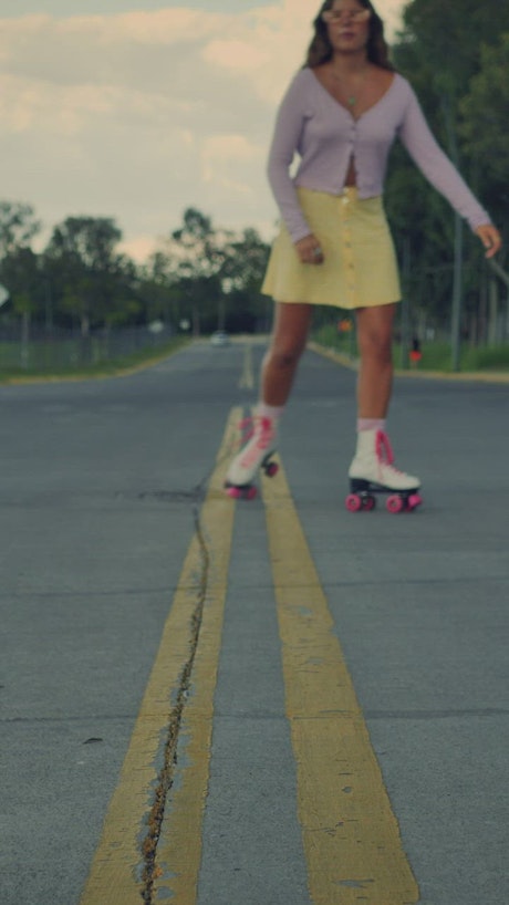Girl approaching skating down the middle of the street.