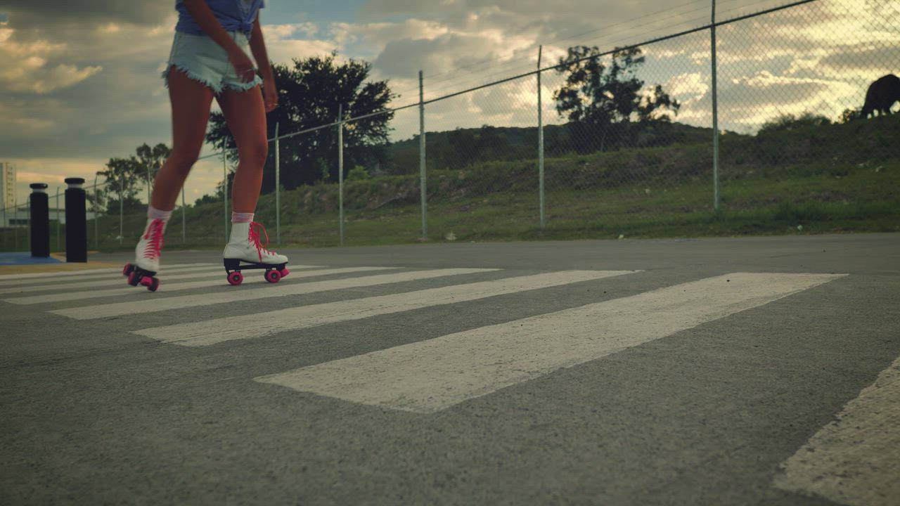 Girl crossing an empty street skating on roller skates