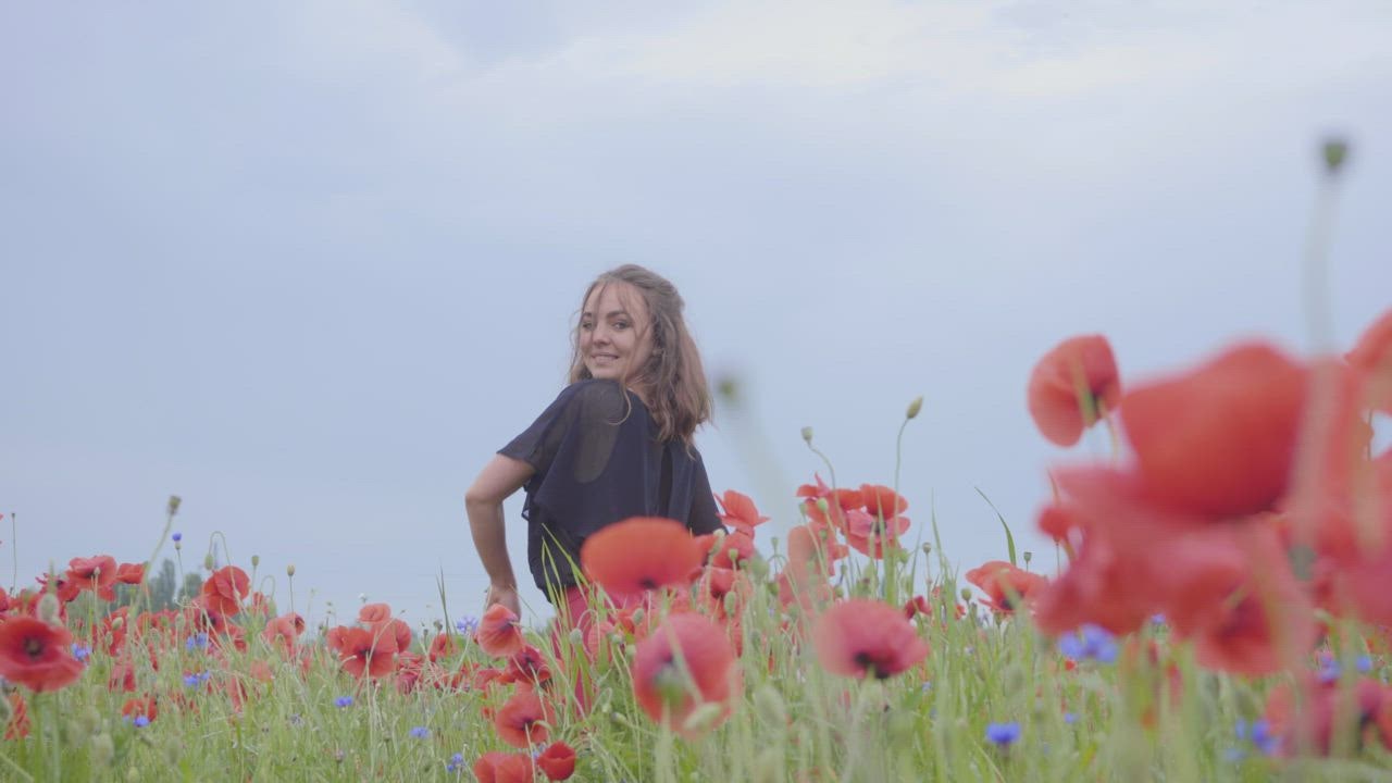 Girl dancing happily in a field of flowers.