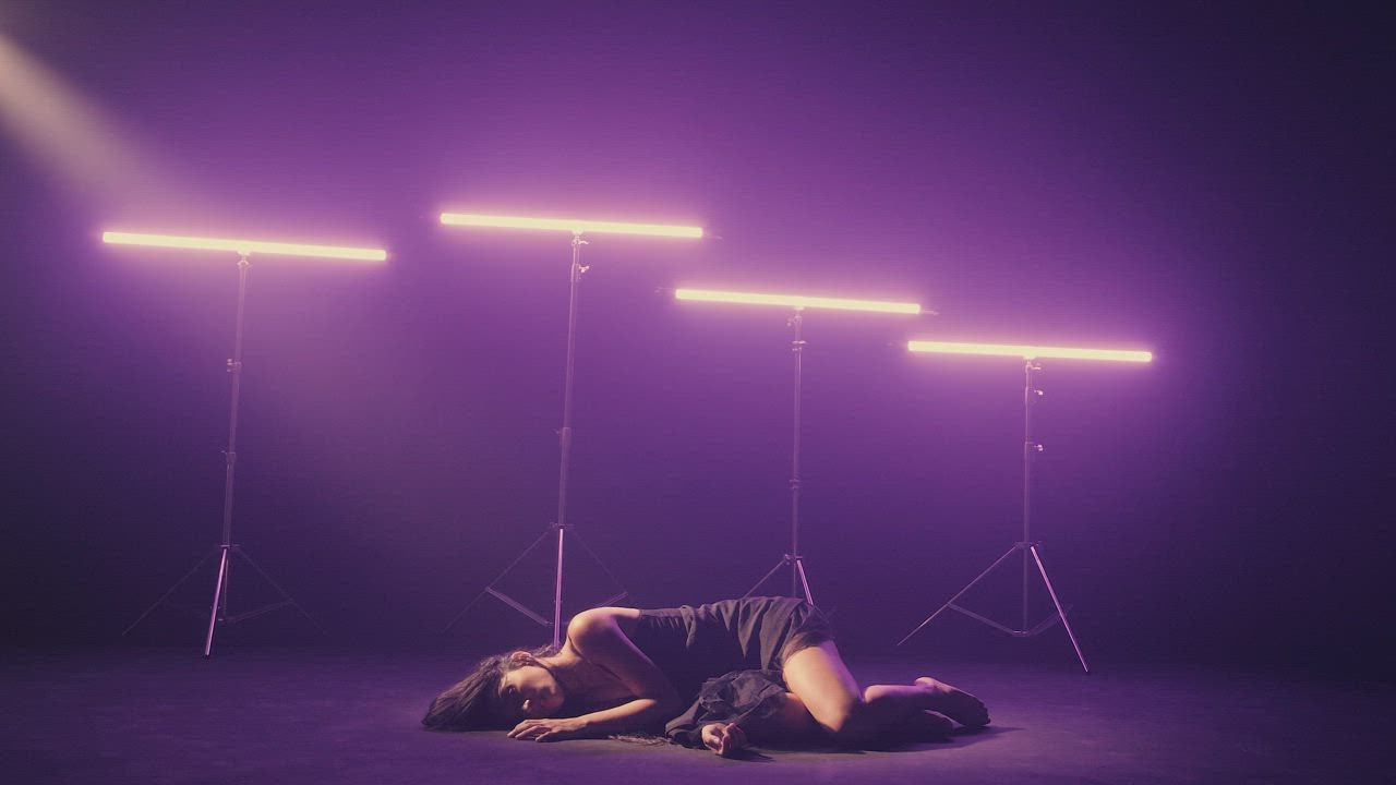 Girl dancing on the floor illuminated by neon lights - Free Stock Video