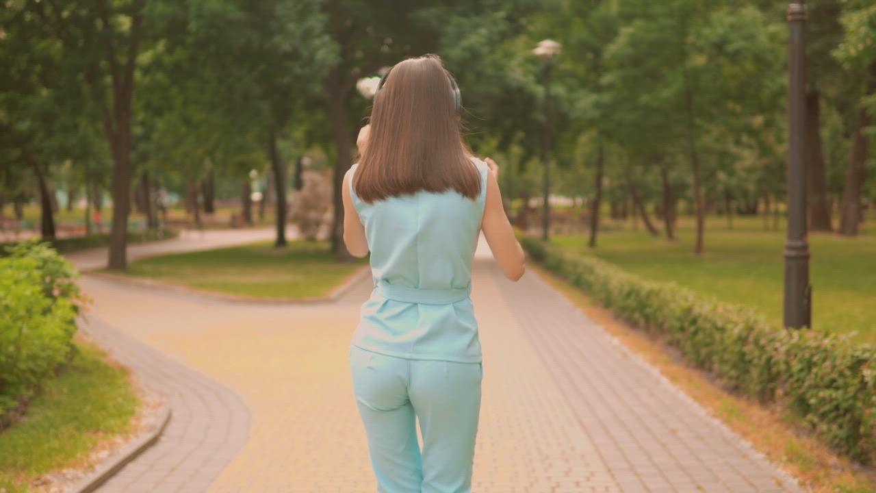 Girl dancing with her  live draw super wuhan headphones while taking a walk