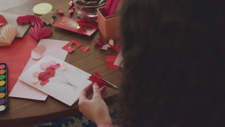 Girl decorating a valentine card.