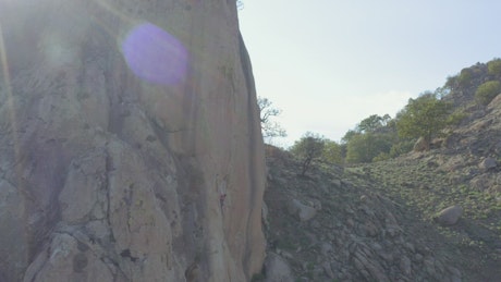 Girl descending a rocky hill with the help of a harness.