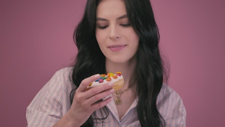 Girl eating a glazed donut with a milkshake.