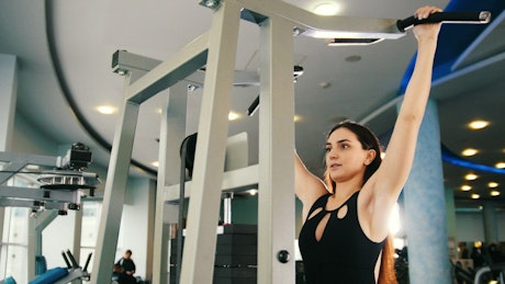 Girl exercising with a machine in a gym.