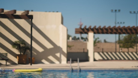 Girl in bikini poses to the camera near a pool