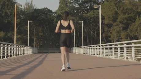 Girl in sportswear jogging outdoors.