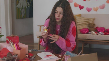 Girl making a decorated valentine's card.
