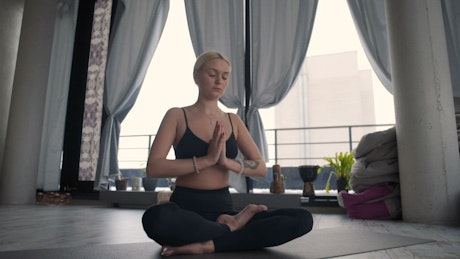 Girl meditating over a yoga mat.
