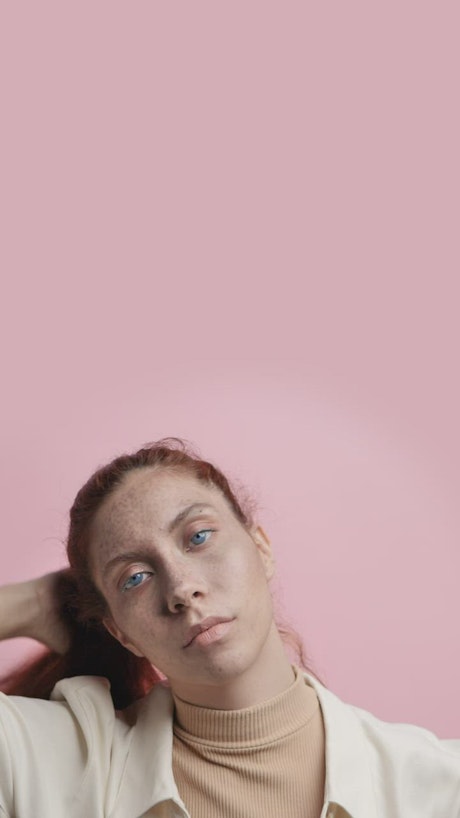 Girl modeling captivatingly on a pink background.
